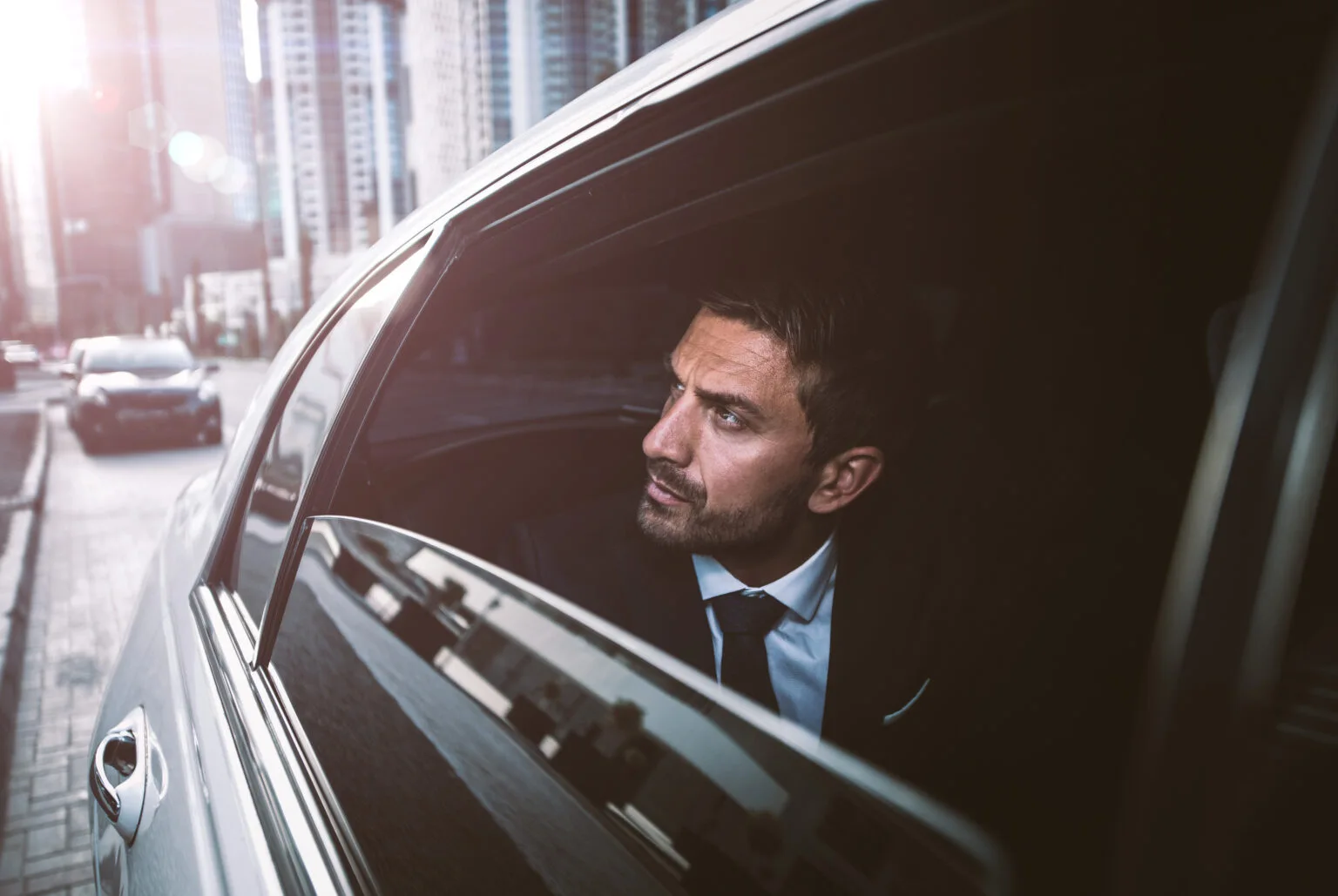 Geschäftsmann reist entspannt im Fond einer Limousine
