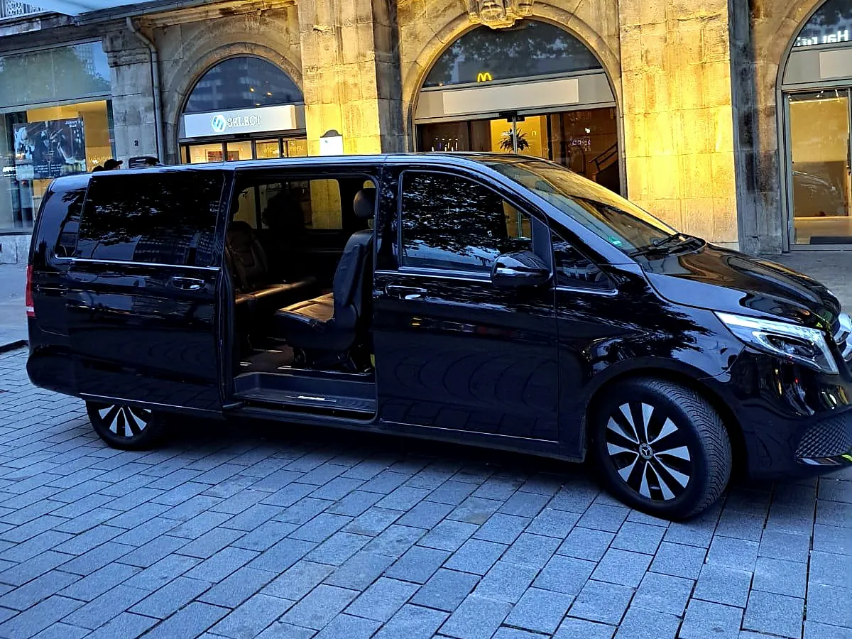 Mercedes V-Klasse mit geöffneter Tür vor einem Hotel am Abend